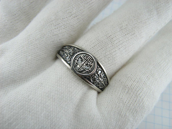Solid 925 Sterling Silver signet ring decorated with cross and filigree pattern on the oxidized background.