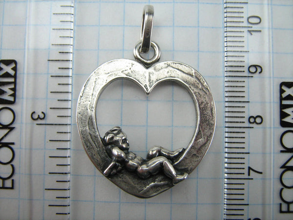 Vintage solid 925 Sterling Silver oxidized necklace pendant depicting cupid with wings lying in the heart.