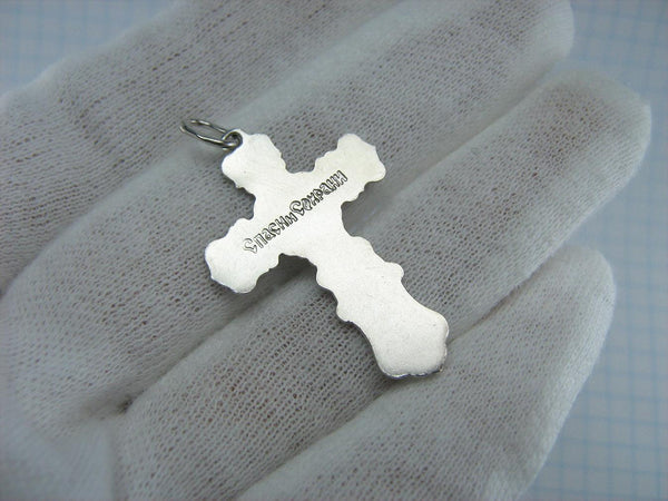 Silver cross pendant and crucifix with Christian blessing prayer.