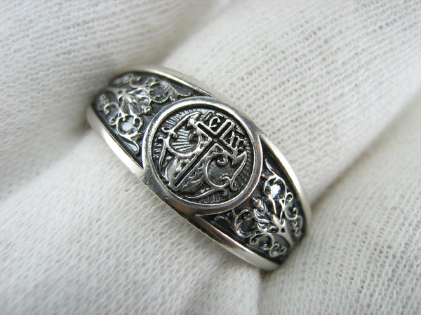 Solid 925 Sterling Silver signet ring decorated with cross and filigree pattern on the oxidized background.