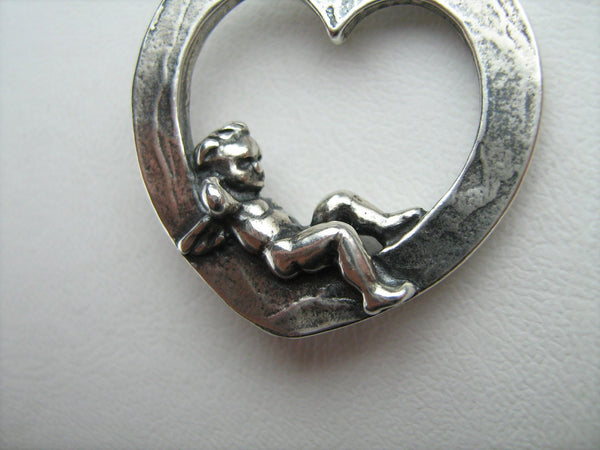 Vintage solid 925 Sterling Silver oxidized necklace pendant depicting cupid with wings lying in the heart.